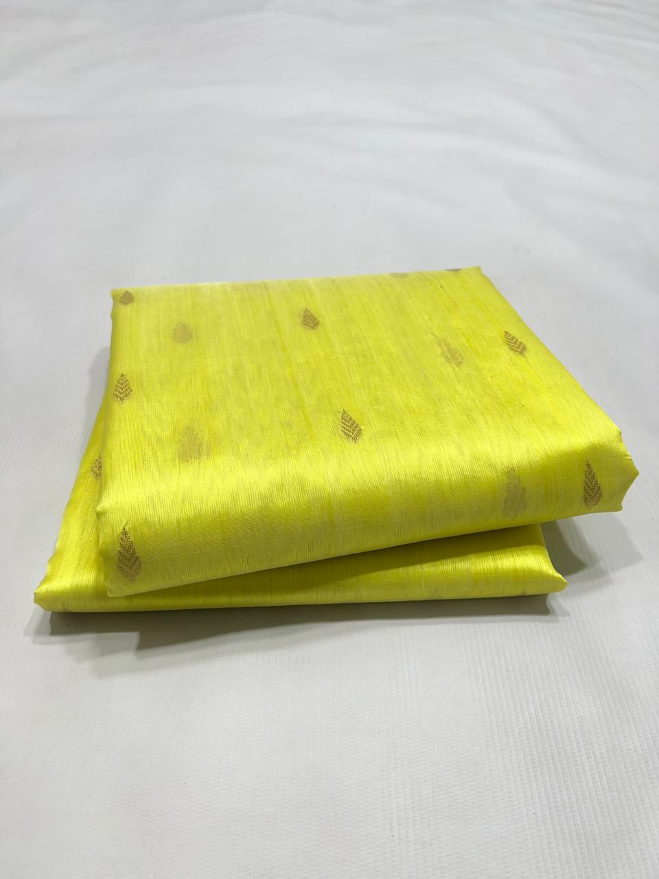 Premium handloom lemon yellow soft silk Chanderi saree featuring delicate leaf-patterned zari buttis, neatly folded
