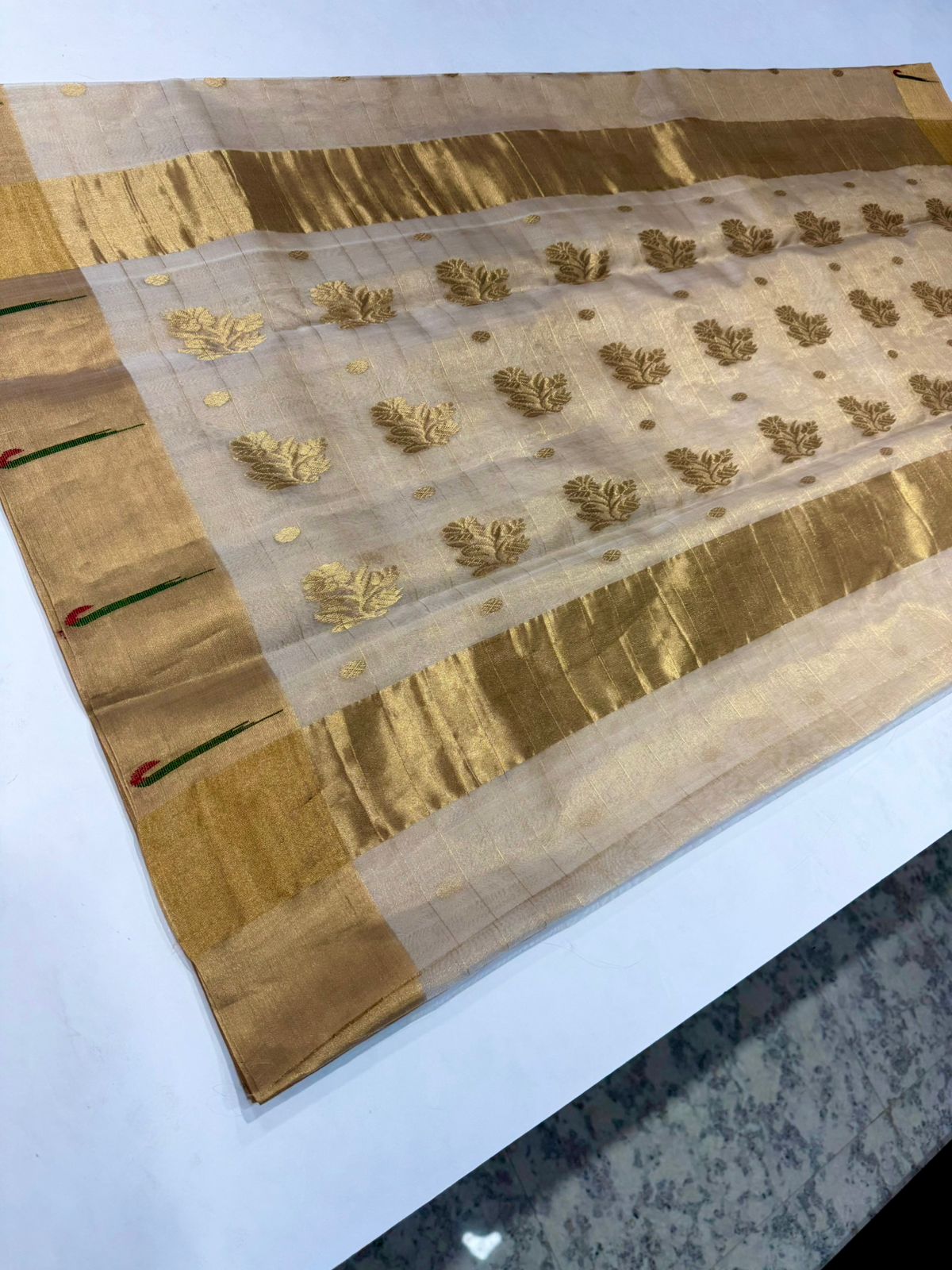 Champagne gold Chanderi Katan silk saree pallu featuring large woven gold leaf motifs and a thick zari border.