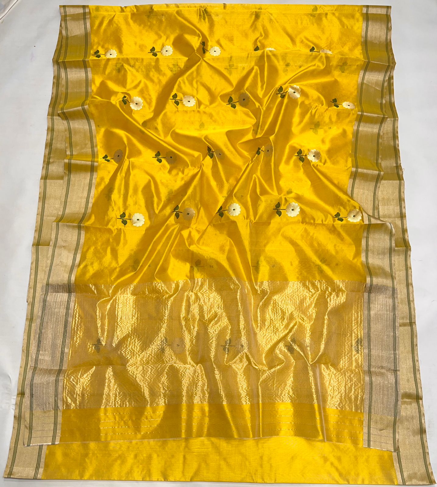 Flat lay view of the Sunflower Yellow Chanderi Pattu Saree showing the complete pattern of hand-woven floral buttis and the detailed gold zari pallu work.