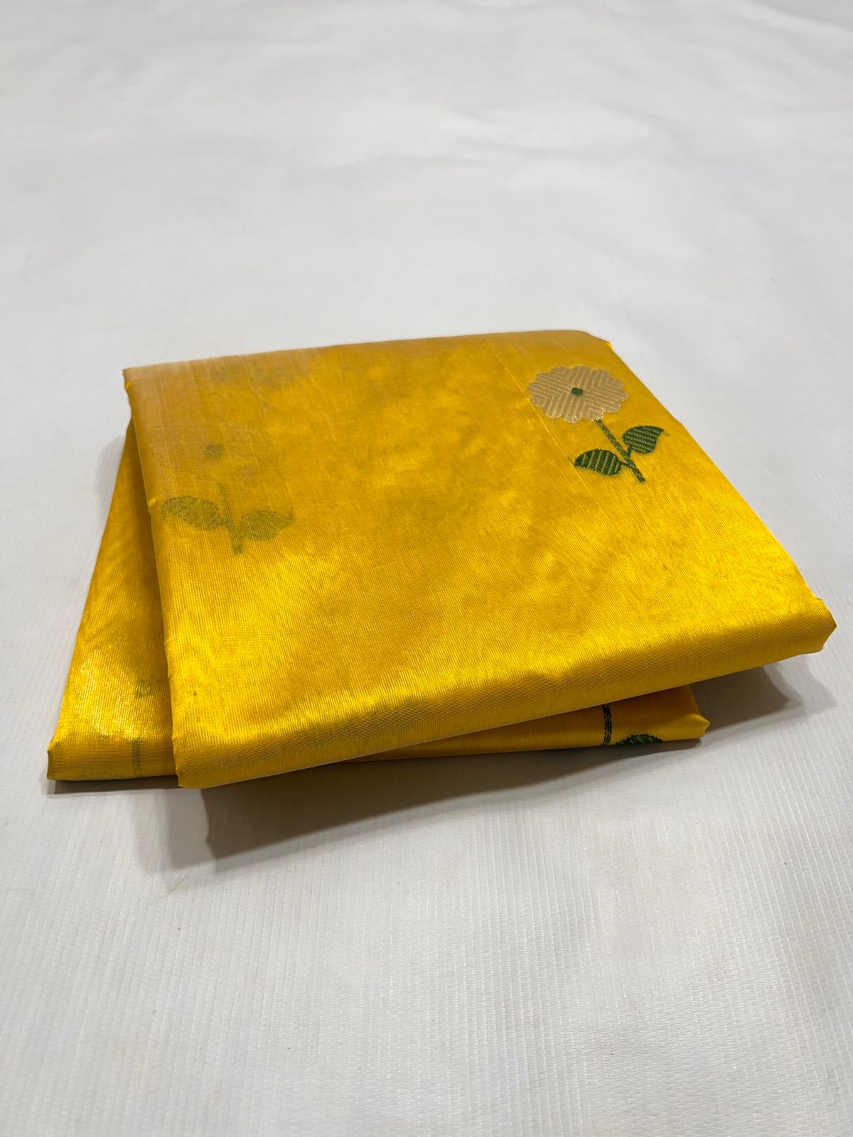 Authentic folded Radiant Sunflower Yellow Chanderi Pattu Handloom Saree showing intricate hand-woven floral buttis