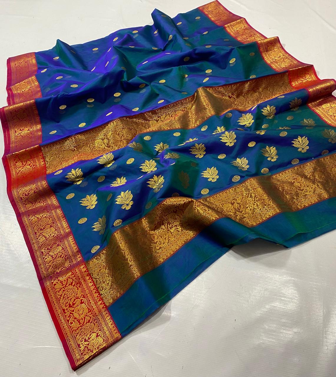 Royal Peacock Blue Chanderi Katan Silk Saree, elegantly draped to highlight the all-over gold coin butti work and the contrast crimson red zari border. Premium wedding handloom