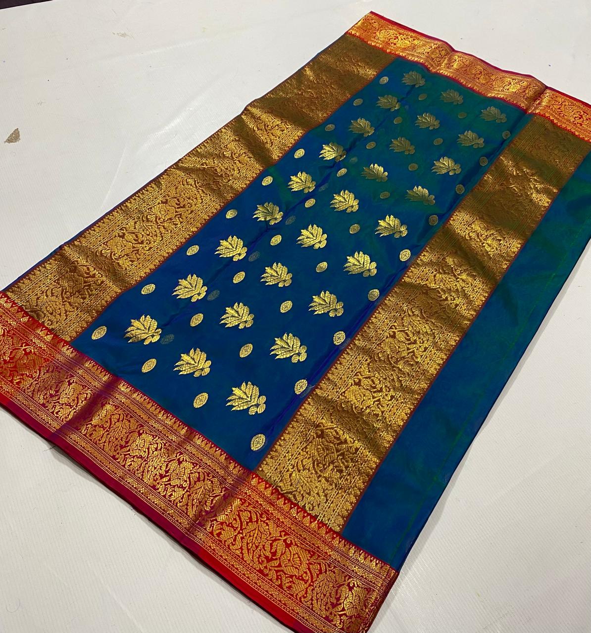 Close-up view of the intricate gold zari pallu on the Royal Peacock Blue Chanderi Katan Silk Saree, featuring traditional motifs with a crimson red border.