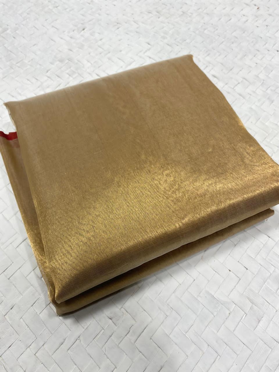 Premium Antique Gold Chanderi Tissue saree neatly folded to show the high-luster metallic finish and lightweight fabric quality